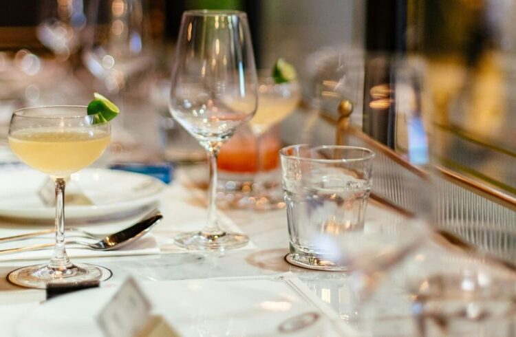 A table laid for a meal, with various glasses and including cocktails