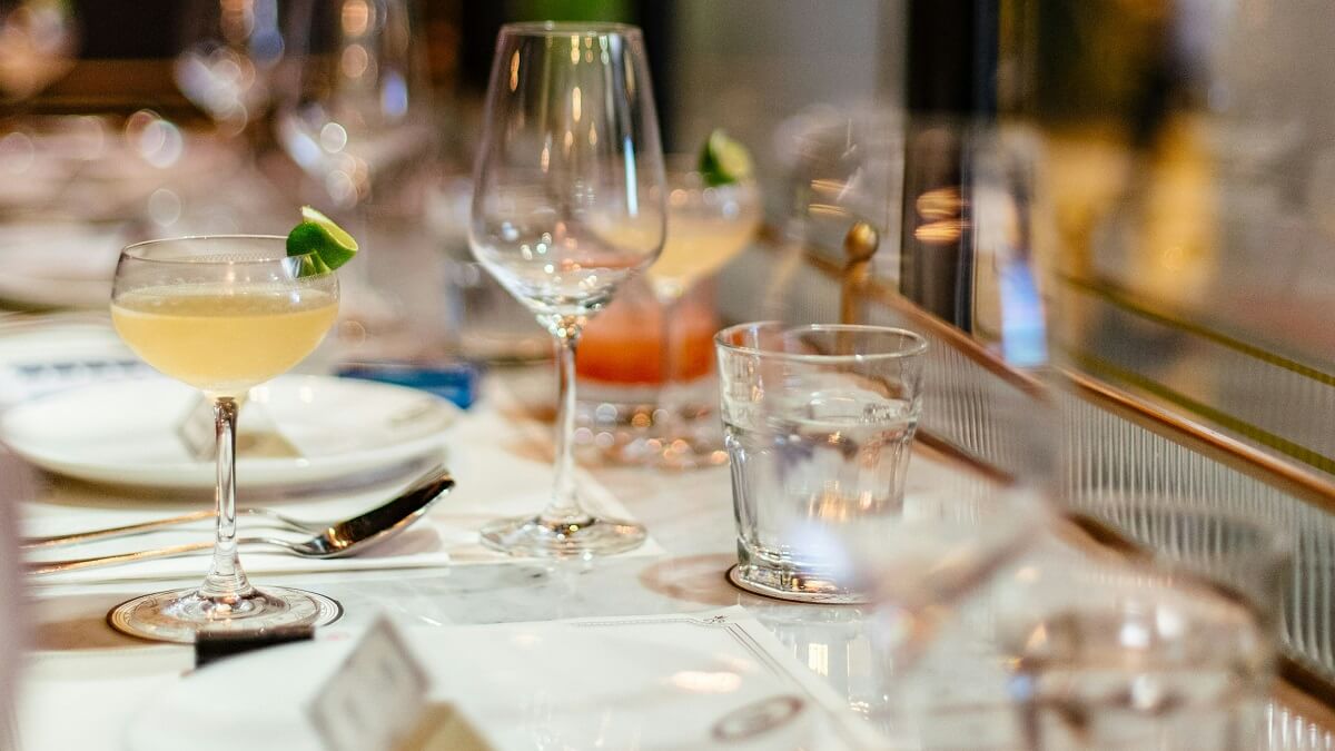 A table laid for a meal, with various glasses and including cocktails