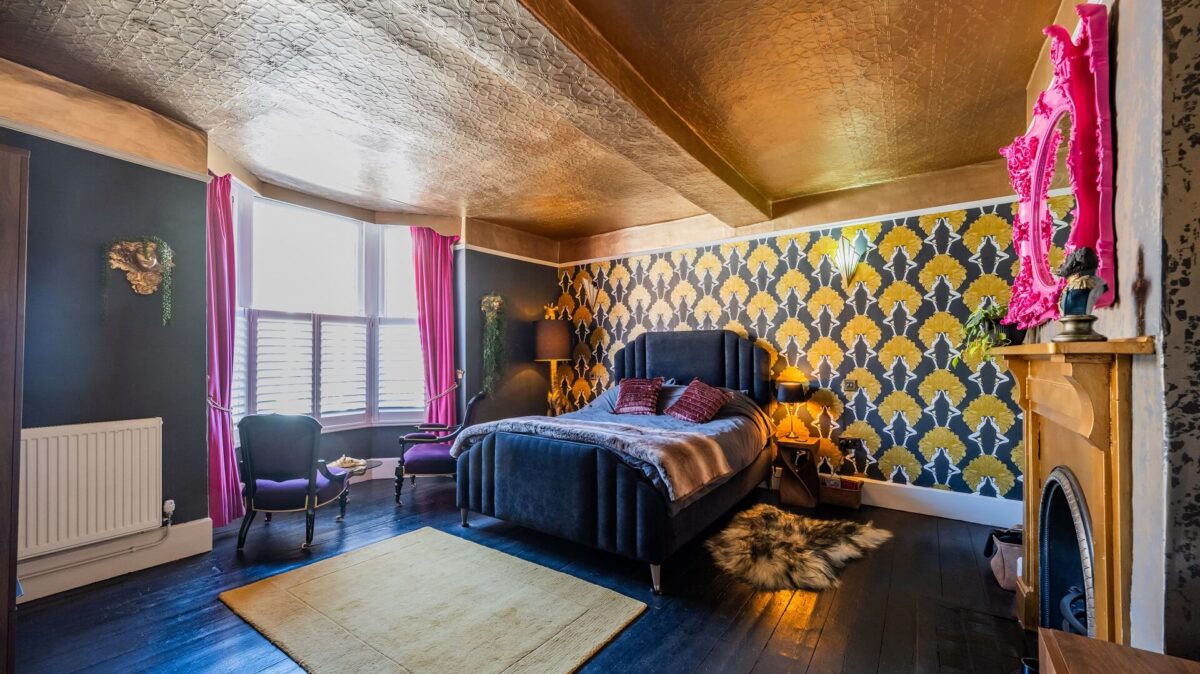 Bedroom at J Maverick decorated colourfully with pink, gold and navy