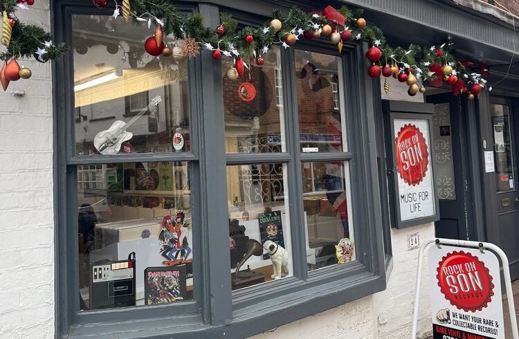 Exterior view of Rock On Son Records - windows painted grey and sign outside showing business name on red background