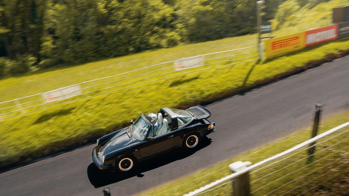 A convertible Porsche being driven at Shelsley Walsh Hill Climb